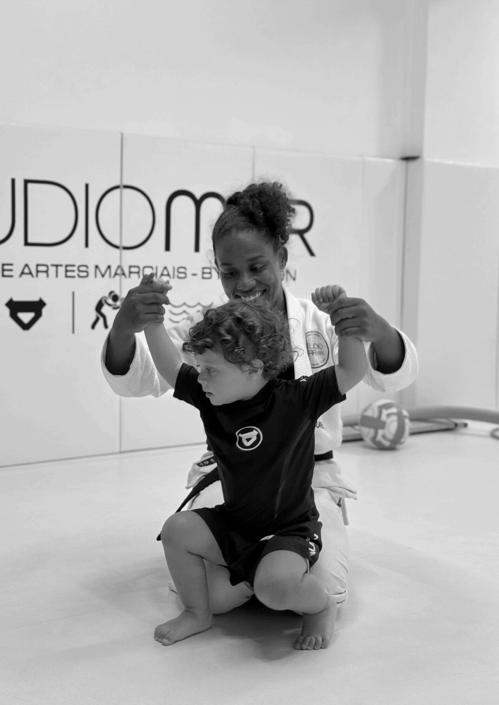 Professora da Studio Mar treinando uma criança no jiu-jitsu